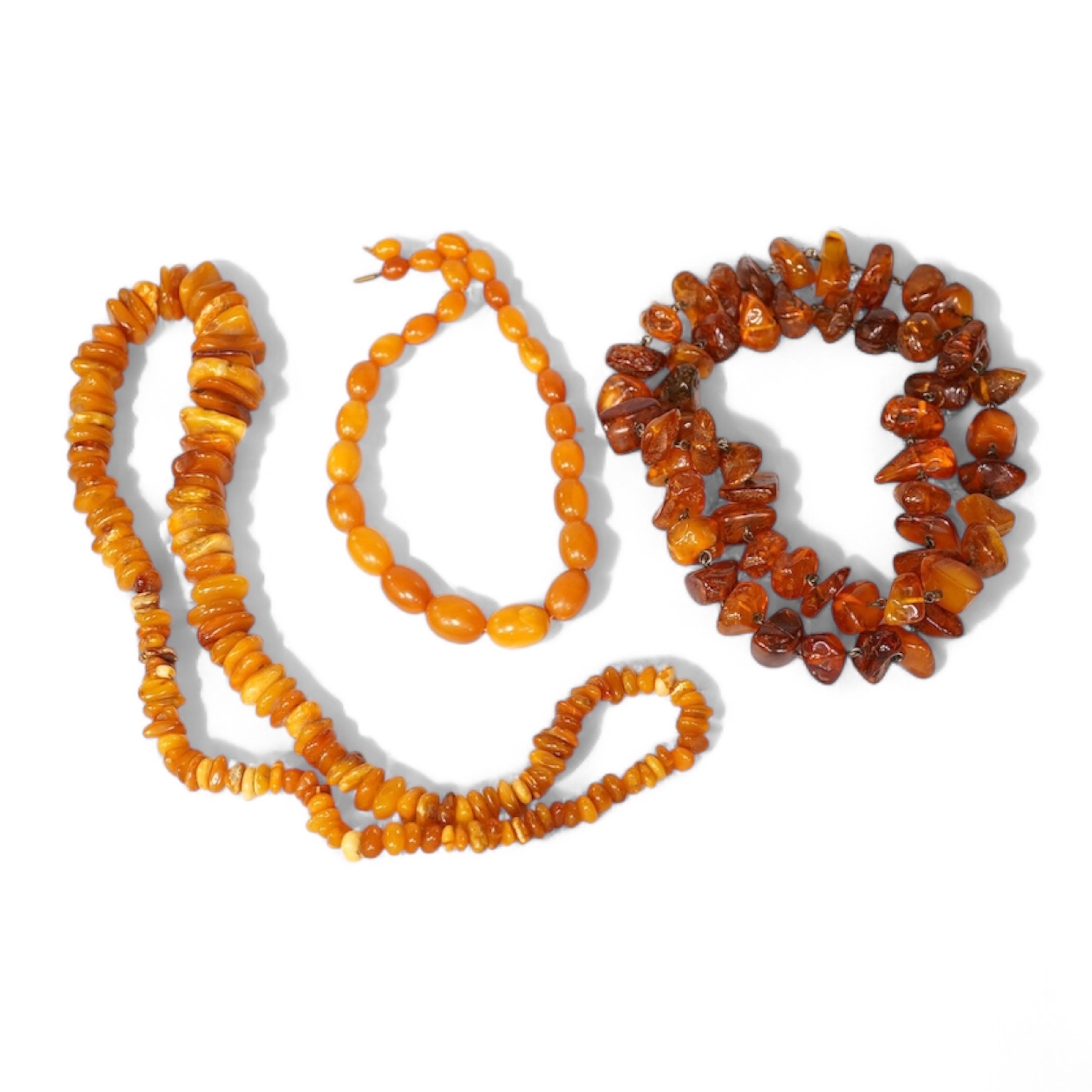Three assorted amber necklaces including a single strand graduated oval bead necklace, 40cm, gross weight 37 grams, the other two necklaces gross weight 240 grams. Condition - poor to fair